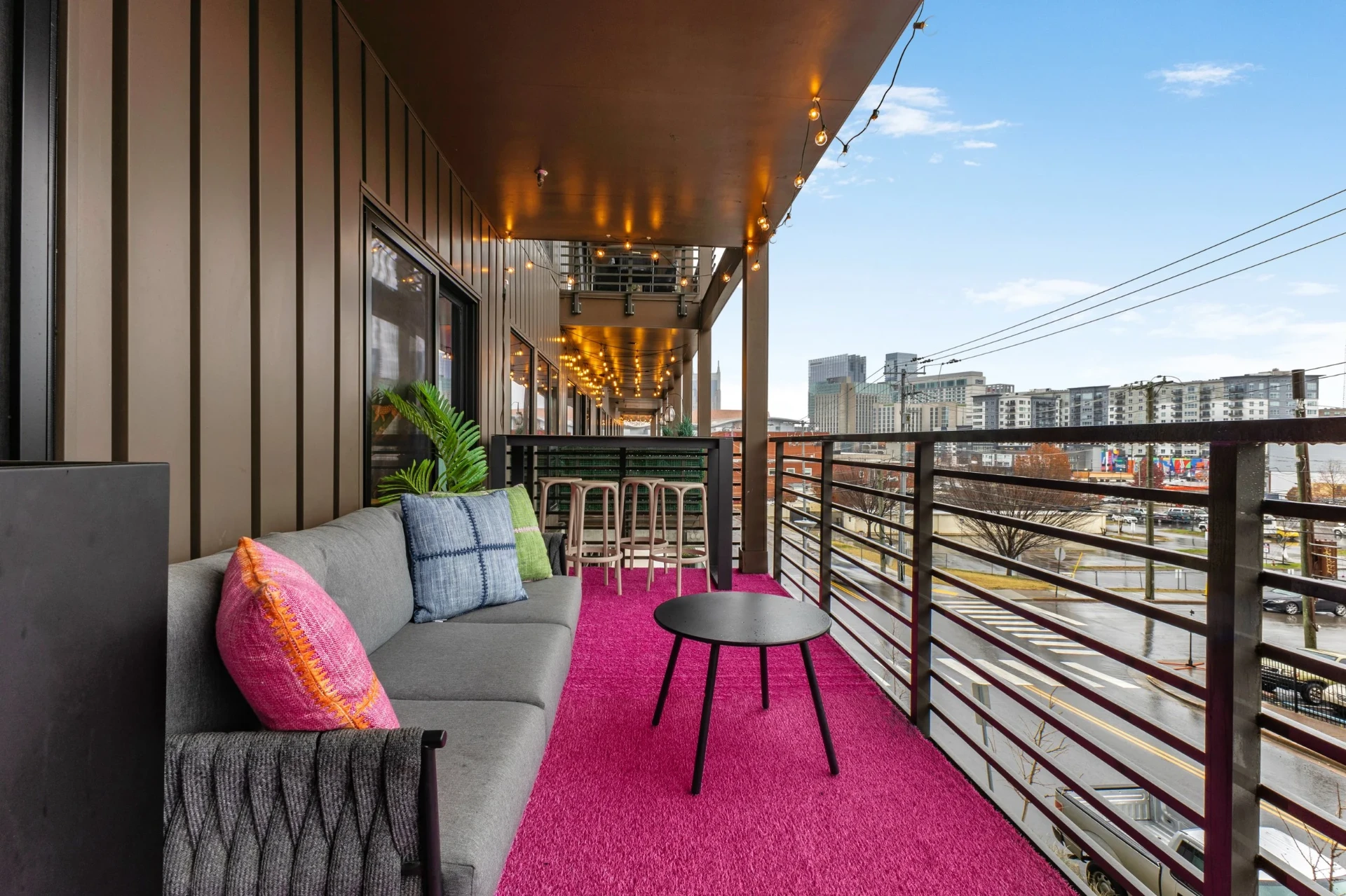 Balcony lounge with skyline & string lights